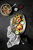 Fried chicken with herbs and pomegranate seeds, served with a side of rice