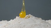 Egg falling into flour, slow motion