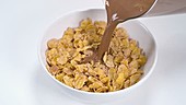 Chocolate pouring on cereal, slow motion