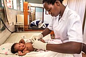 Hospital nurse removing newborn baby's umbilical cord