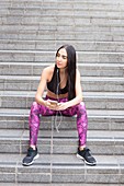 Woman sitting on steps listening to music