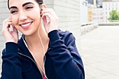 Woman wearing earphones, smiling