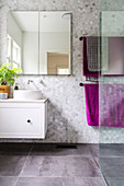 Spiegelschrank, Waschtischmöbel und Handtuchhalter in gelfiestem Badezimmer