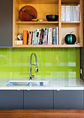 Fitted kitchen with gray base cabinet, green splash guard and open shelf