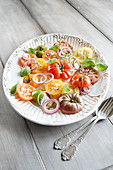 Bunter Tomatensalat mit roten Zwiebeln und Basilikum