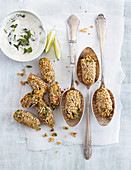 Sesame and chickpea balls on spoons with a mint and lime dip