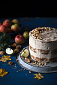 Apple layer cake with walnut frosting, on a dark surface