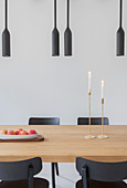 Black pendant lamps above dining table and black chairs
