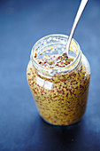 Coarse mustard in a glass with a spoon