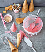 Ice cream cones with pink icing and cake decorations