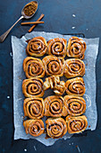 Zimtschnecken mit Zuckerglasur auf Backpapier