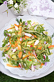 Summery cucumber salad with carrots, radishes, asparagus and dill