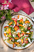 Summery rocket and apricot salad with tomatoes, radishes and goat's cheese
