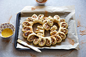 A pretzel made from cinnamon buns on a baking tray