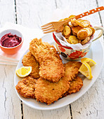 Viennese style schnitzel with fried potatoes and lingonberry sauce