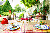 Gedeckter Tisch mit Mosaikplatte im sommerlichen Garten