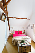 Schmales Schlafzimmer mit hoher Decke und alten Balken