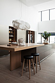 Island counter with breakfast bar extension in open-plan kitchen
