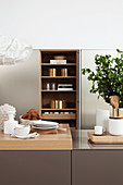 View across island counter to kitchen utensils on open shelves