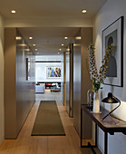 Modern hallway with panelled walls and view into living room