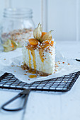 A piece of coconut cake with physalis