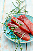 Fresh tuna fish steaks and saltwort on a plate