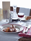Shoulder of lamb served with red wine on a bistro table