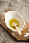 Olive oil with a spoon in a porcelain dish