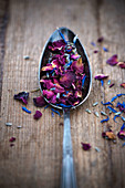 Dried, edible flower petals on a spoon
