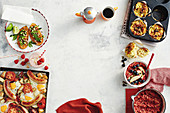 Muffins mit Würstchen, Porridge mit Apfel und Roter Bete, Würschten mit Spiegelei und Tomaten aus dem Ofen, Himbeersmoothie und Süsskartoffel-Toast mit Sataysauce