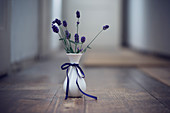 Fresh lavender flowers in a vase on a wooden floor