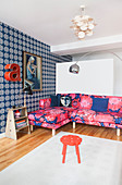 Pink, patterned sofa and blue wallpaper in living room