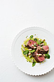 Lamb with green pea hummus and white beans