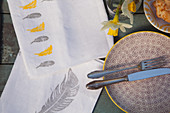 Linen napkins printed with feathers on Easter table