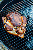 A whole chicken on a barbecue rack