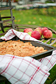 Apple pie in a tin on a garden bench