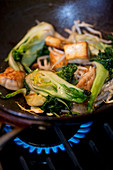 Bok choy with tofu and bean sprouts in a wok