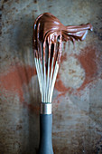 A whisk with chocolate cream (top view)