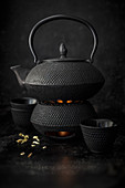 A cast-iron teapot on a teapot warmer