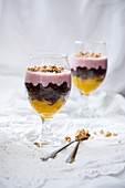Vegan dessert in glasses with mango, chocolate cake, lupine yoghurt and muesli