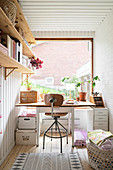 Old table in front of large window in small study