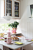 Breakfast table set in pastel shades in kitchen