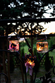 Handmade candle lanterns decorated with lavender hung from fence