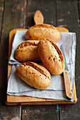 Bread rolls on a chopping board with a knife