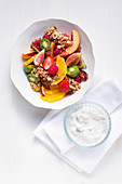 Colourful fruit salad with oats and nut brittle