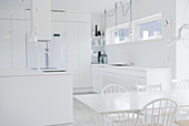 Küche ganz in Weiß mit Esstisch und Kochinsel