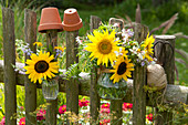 Rural bouquets in glasses tied to fence
