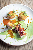 Roasted wild rabbit with crispy bacon and stuffed rice balls arancini and a sweet green pea sauce and gravy