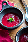 Red beetroot and cabbage soup garnished with kale leaves