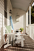 Liegestuhl auf Veranda mit weiß gestrichener Holzverkleidung